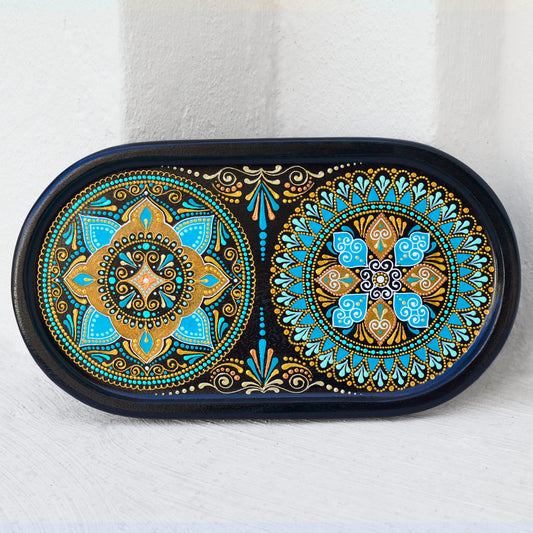 Small oval wooden tray hand-painted with mandala. Moroccan tray for coffee table. Front view on the white wall background.