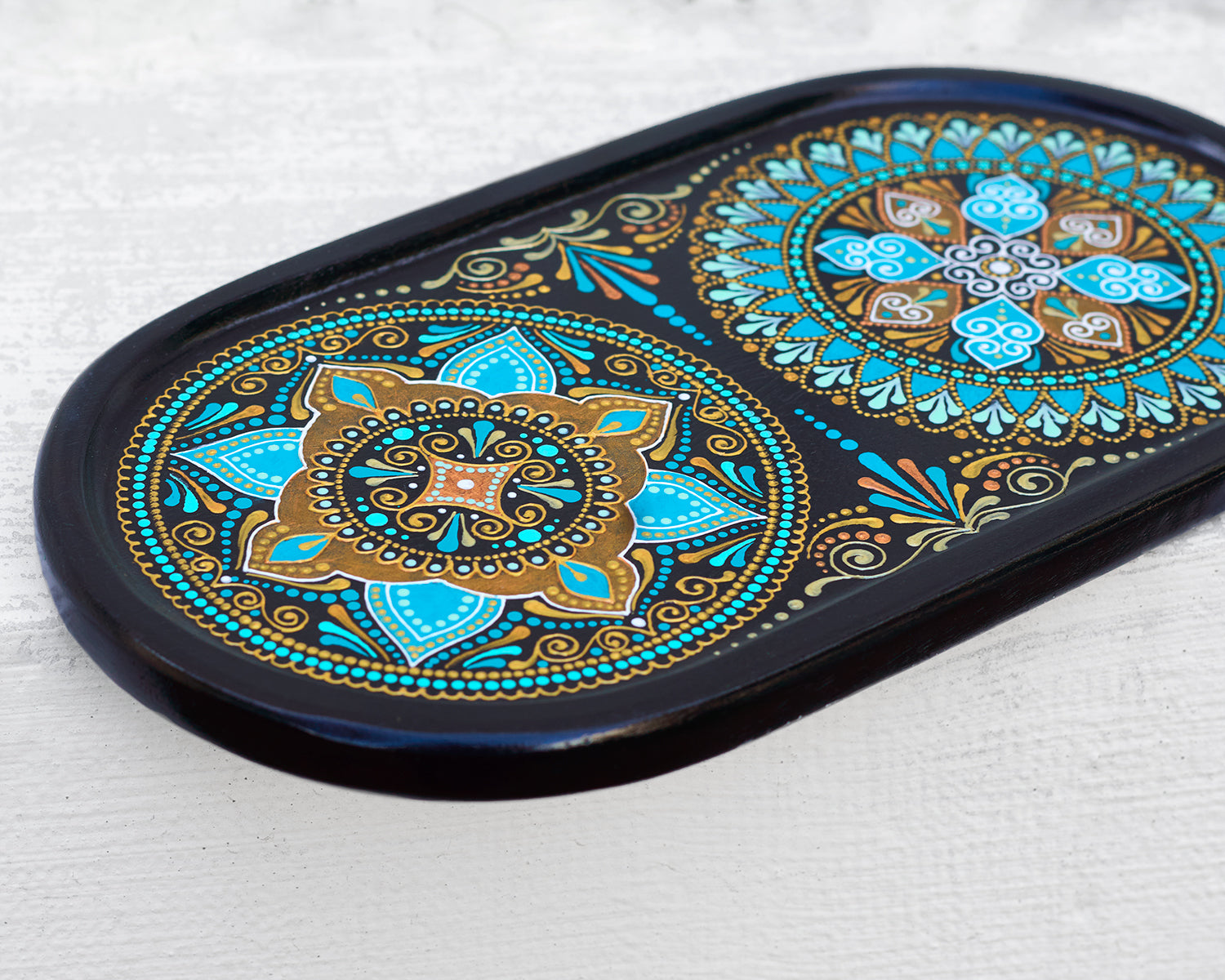 Small oval wooden tray hand-painted with mandala. Moroccan tray for coffee table. Close-up view to show details, on the white background.
