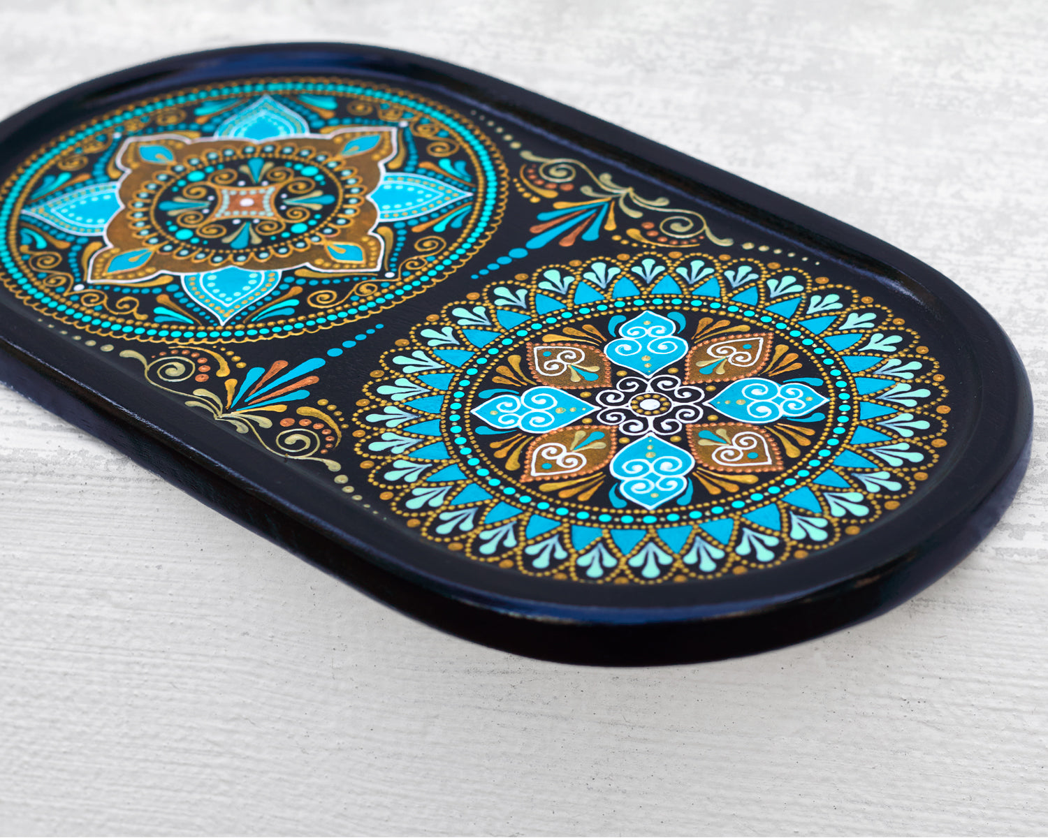 Small oval wooden tray hand-painted with mandala. Moroccan tray for coffee table. Close-up view to show details, on the white background.