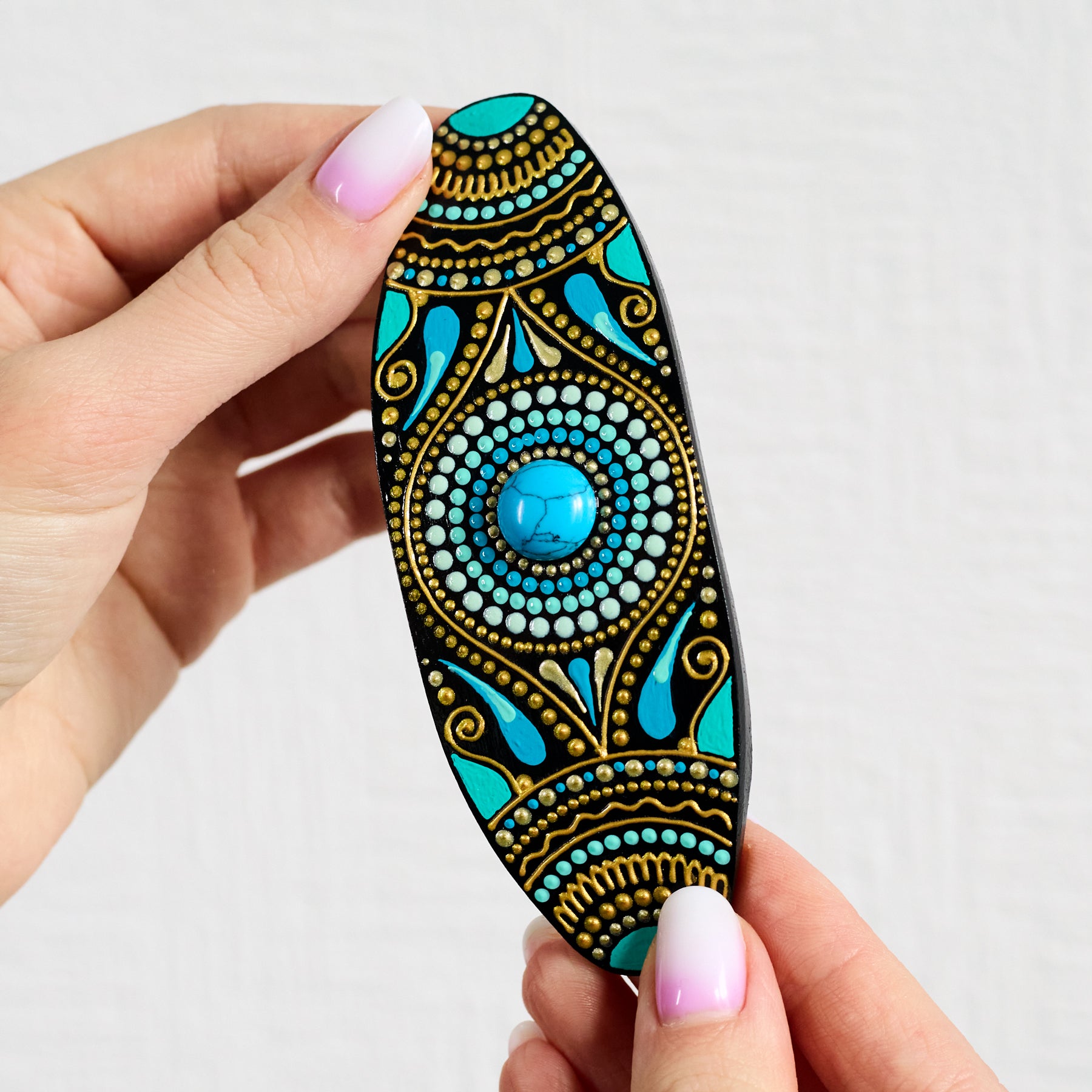 Woman's hands holding turquoise blue hand-painted hair barrette made of lightweight wood, unique gift for her