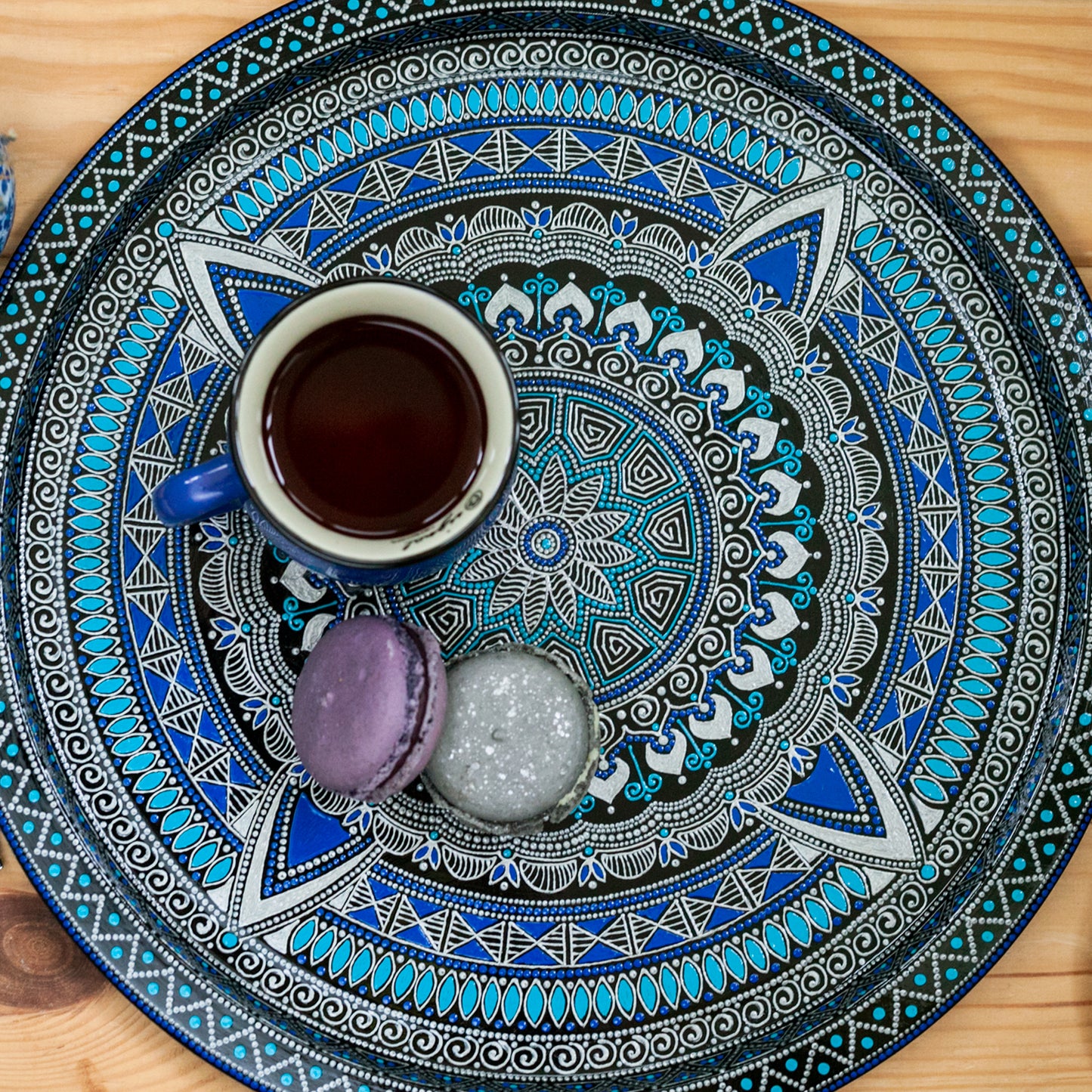Blue round serving tray for ottoman, from Moroccan collection. Top view with coffee cup and cookies on it.