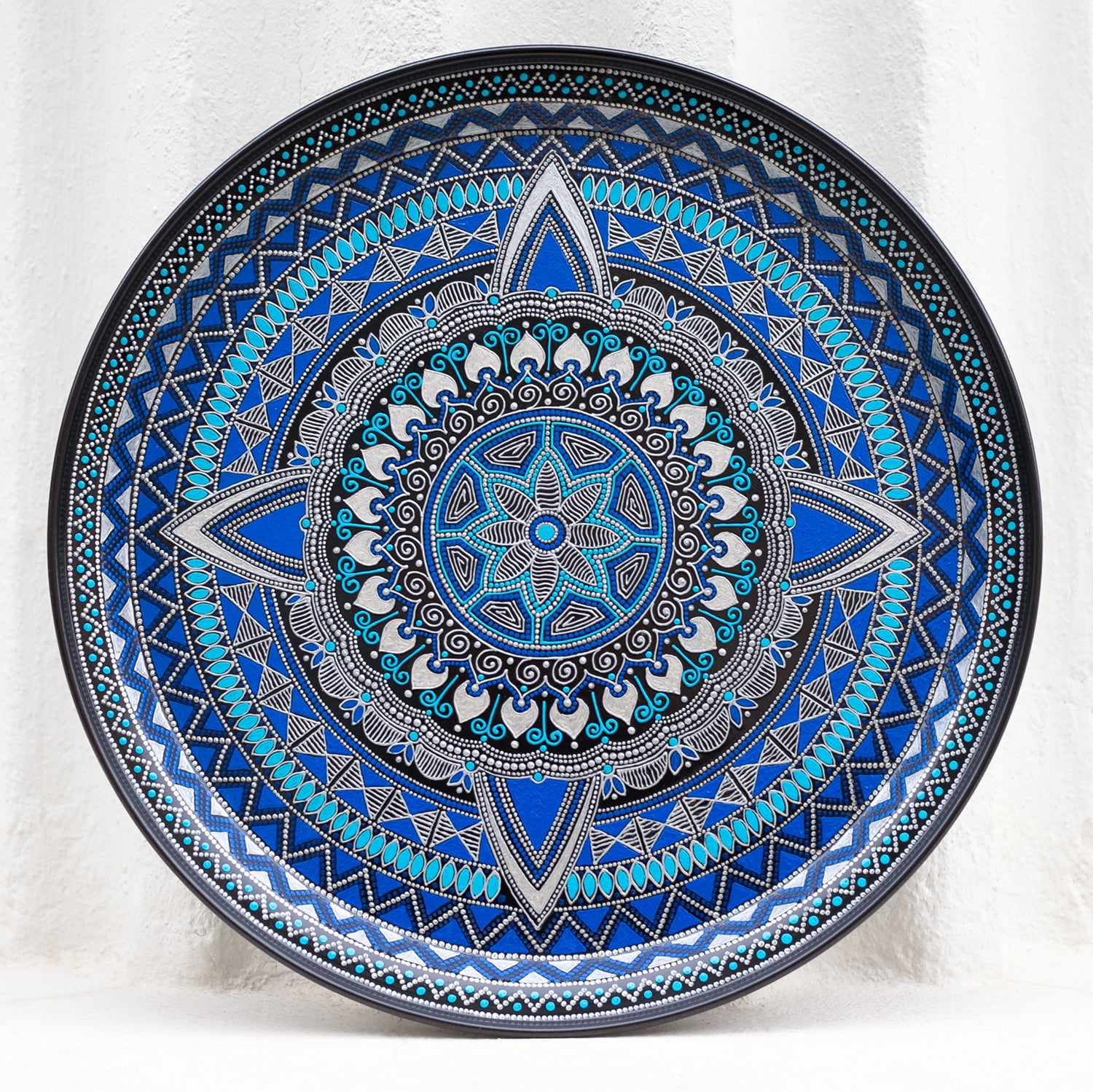 Blue round metal serving tray for ottoman, from Moroccan collection made in blue. Front view on the white background.