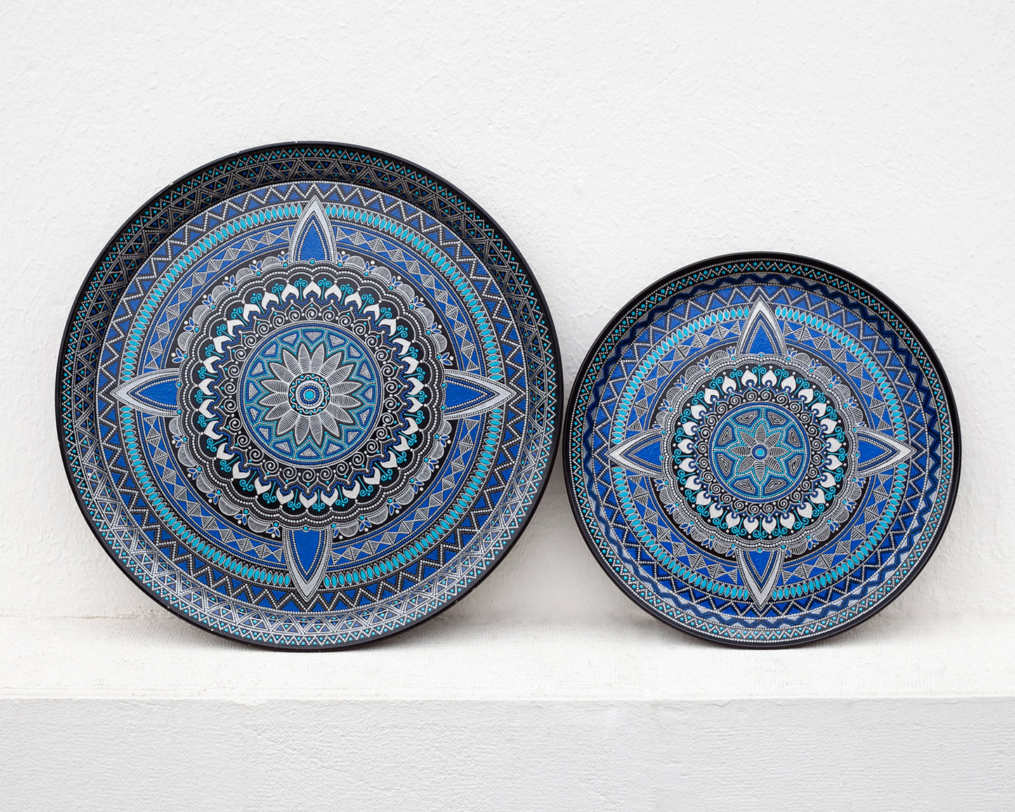 Two blue round metal serving trays from Moroccan collection. Front view on the white background.