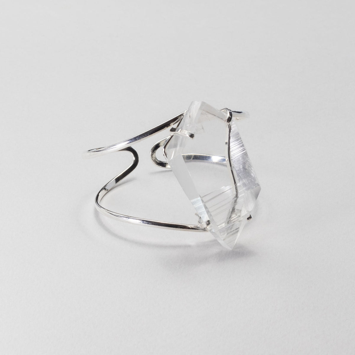 Silver bracelet with a clear gemstone on a light gray background
