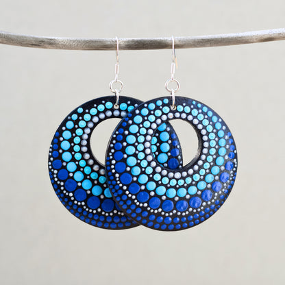Pair of blue dot-patterned earrings on a gray background