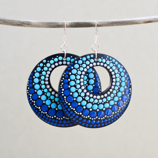 Pair of blue dot-patterned earrings on a gray background