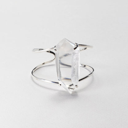 A silver chunky bracelet featuring a clear crystal, photographed on a light gray background.