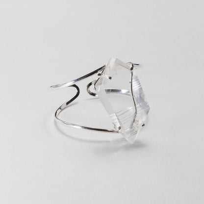 Silver bracelet with a clear gemstone on a light gray background