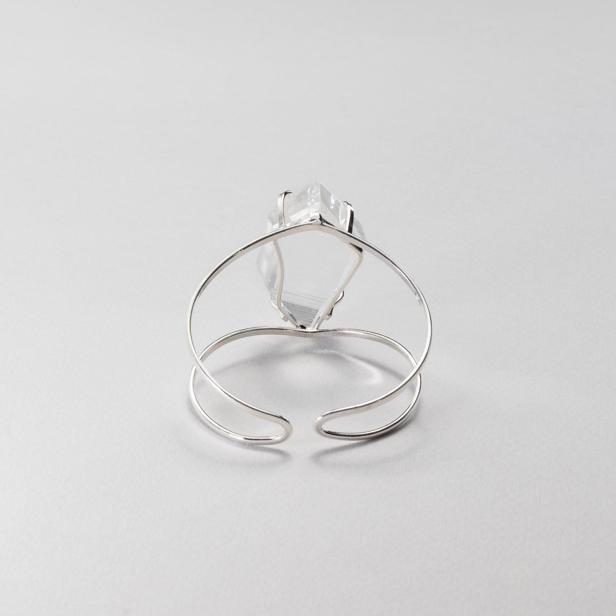 Silver bracelet, view from the back, on a light gray background