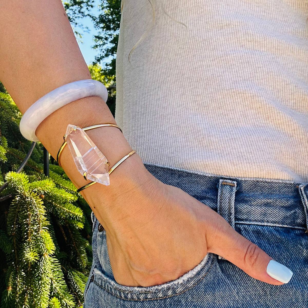 Person wearing clear crystal bracelet with natural background