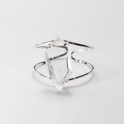 Silver bracelet, featuring a large, faceted clear crystal on a light gray background
