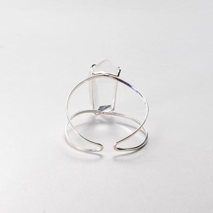 A silver-toned bracelet featuring a large, clear rectangular gemstone, photographed on a clean, light gray background.