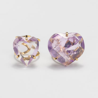 Two amethyst rings featuring faceted clear crystals with a light purple/lavender tint, set against a clean light gray background.