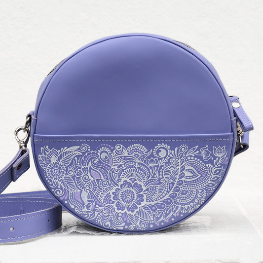Purple round handbag with white floral patterns on a light gray background