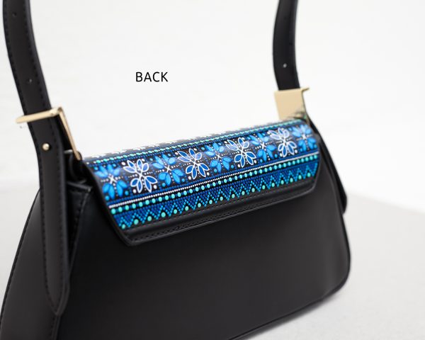 Black leather handbag, close-up view of the back of the bag to show the details of hand-painted blue pattern