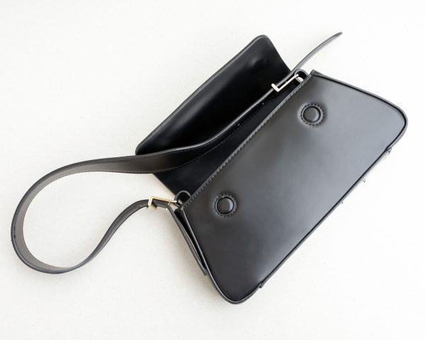 Black small handbag with magnetic closure, view from the top, the bag flap is open